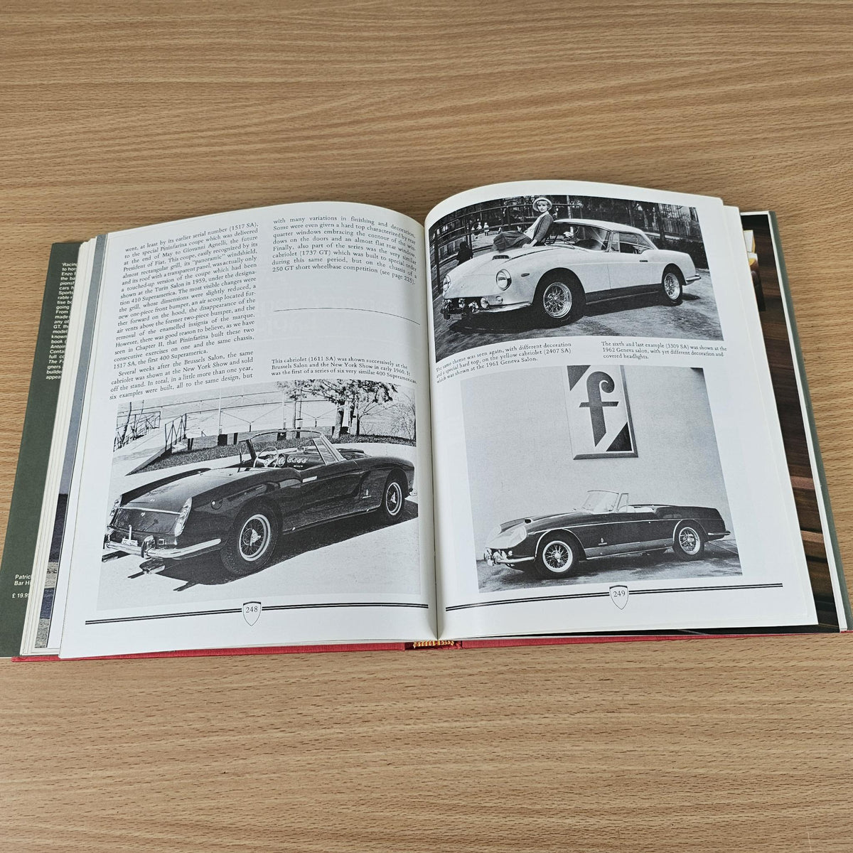 Open classic car photo book with black-and-white car images on both pages.