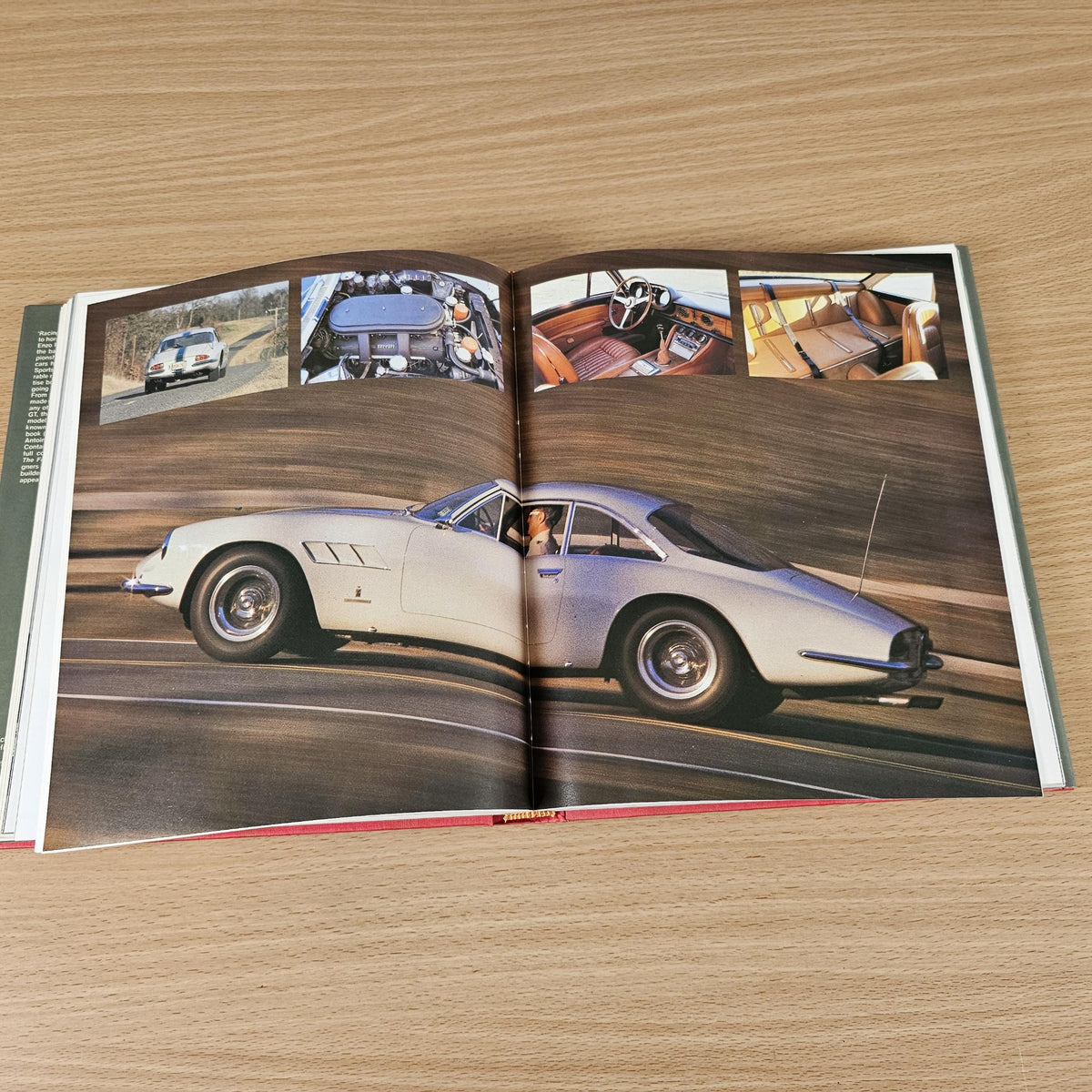 Open classic Ferrari photo book with white road car and cockpit detail images.
