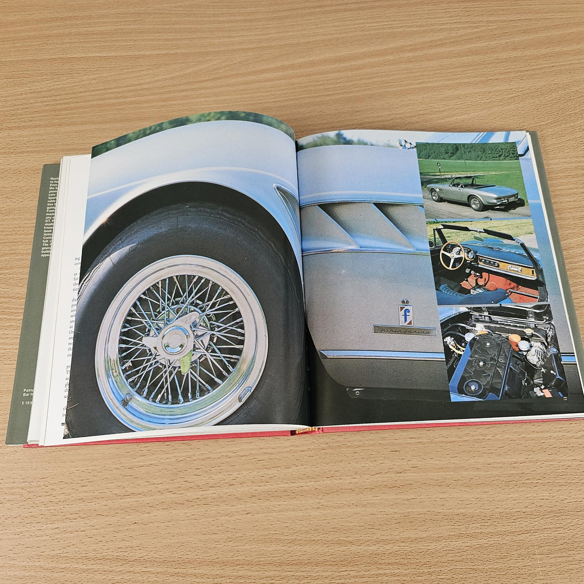 Ferrari road car book, open spread with wheel close-up and color cockpit details.
