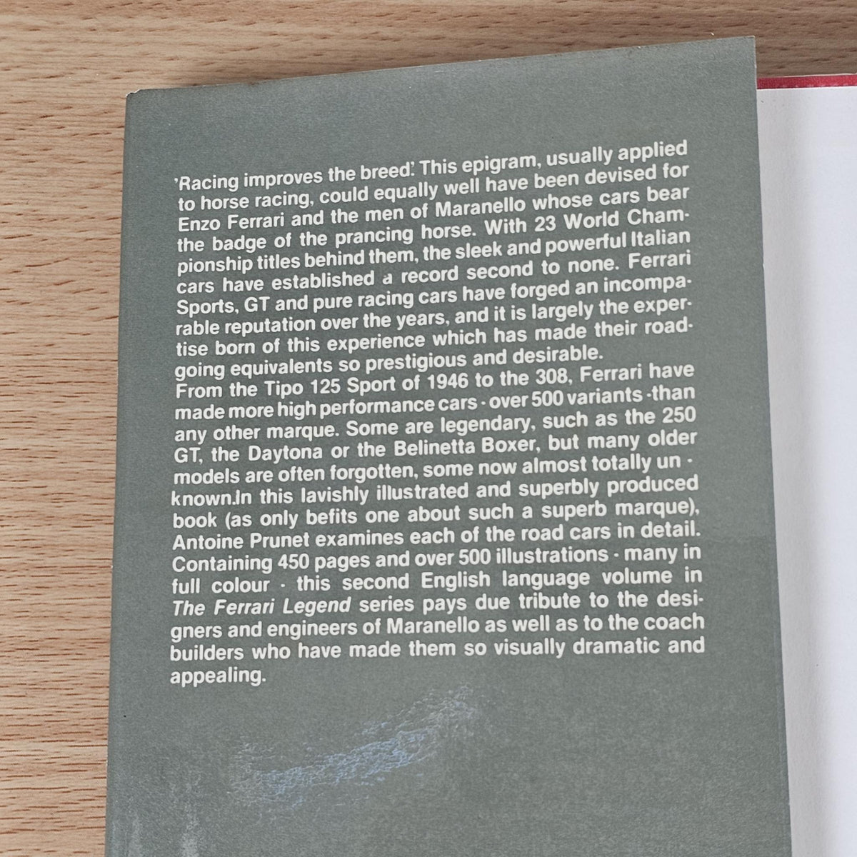 Ferrari book page with dense printed text on a dark gray background