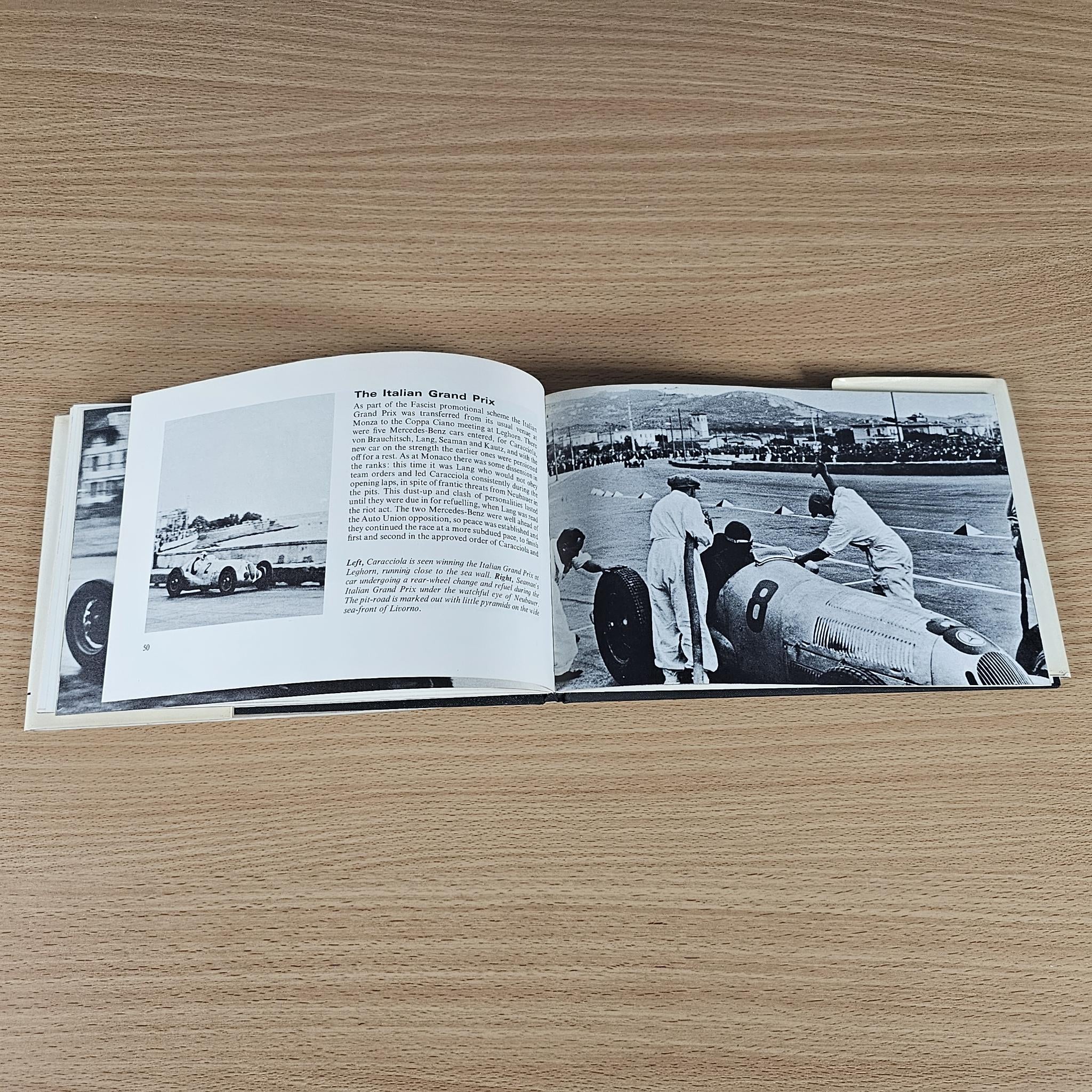 Vintage race photo book, open spread with black-and-white car image and captions