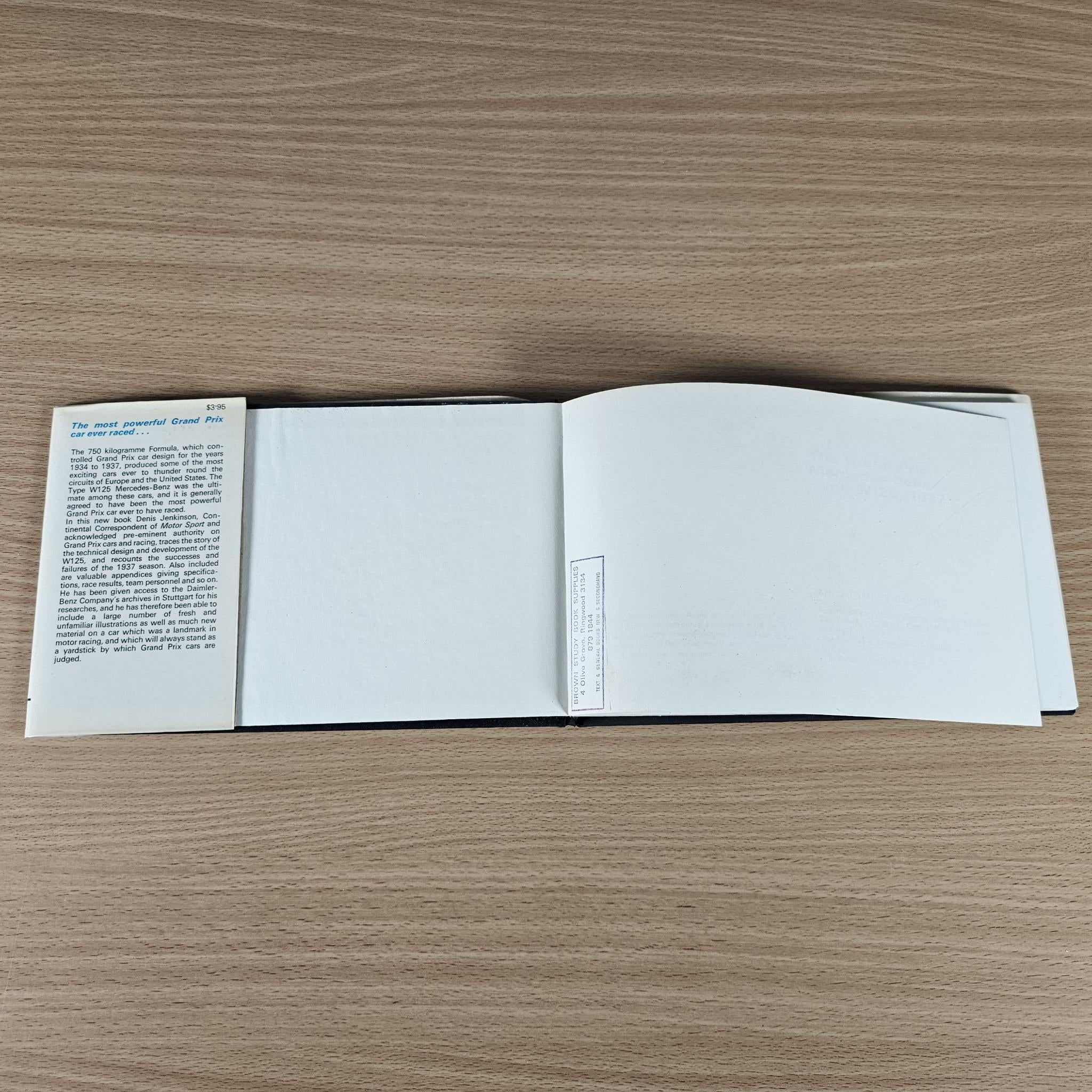 Open race car book with blank pages and small text panel on the left