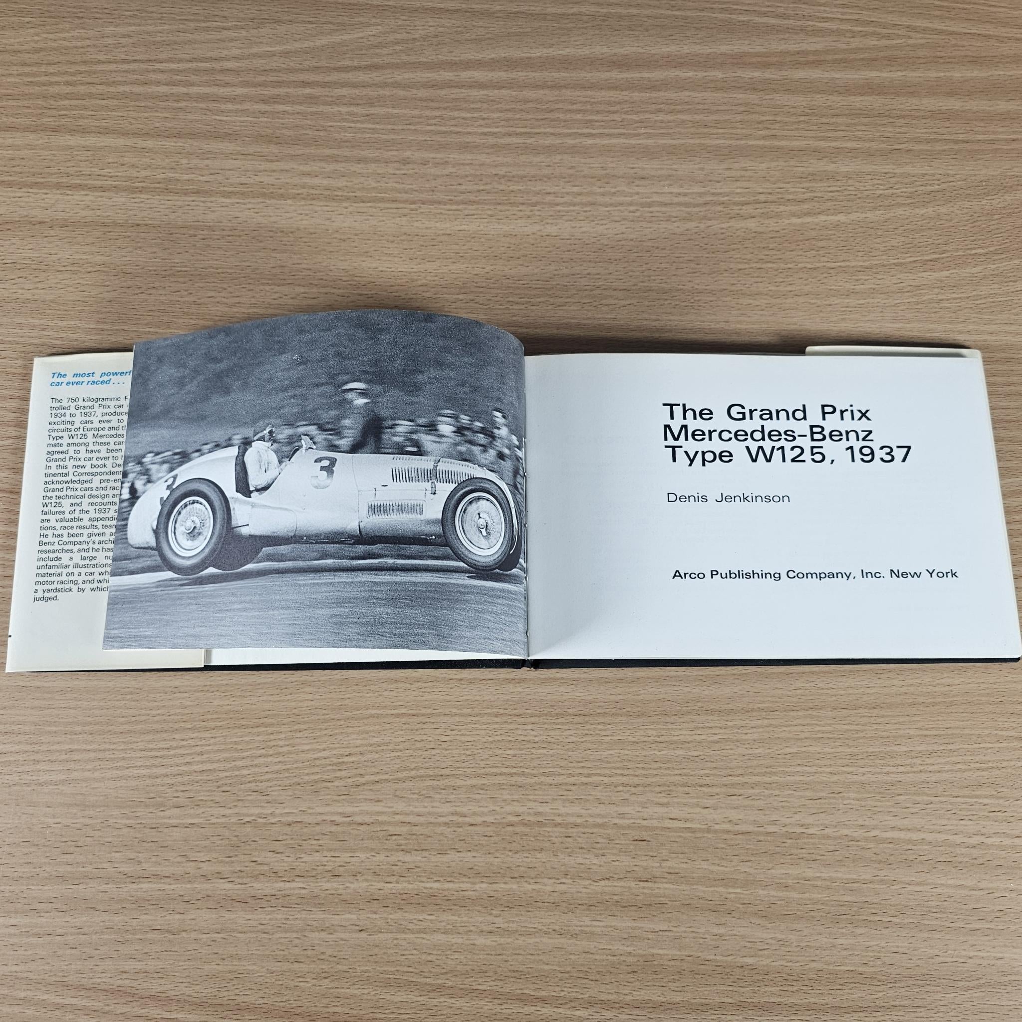 Open race car book with black-and-white car photo spread and text on the right