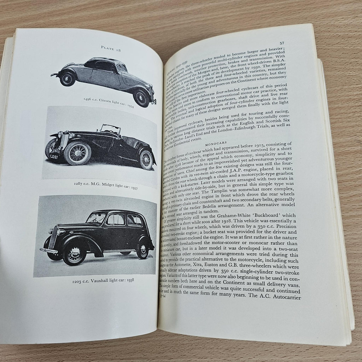 Open paperback book with vintage car illustrations and dense technical paragraphs