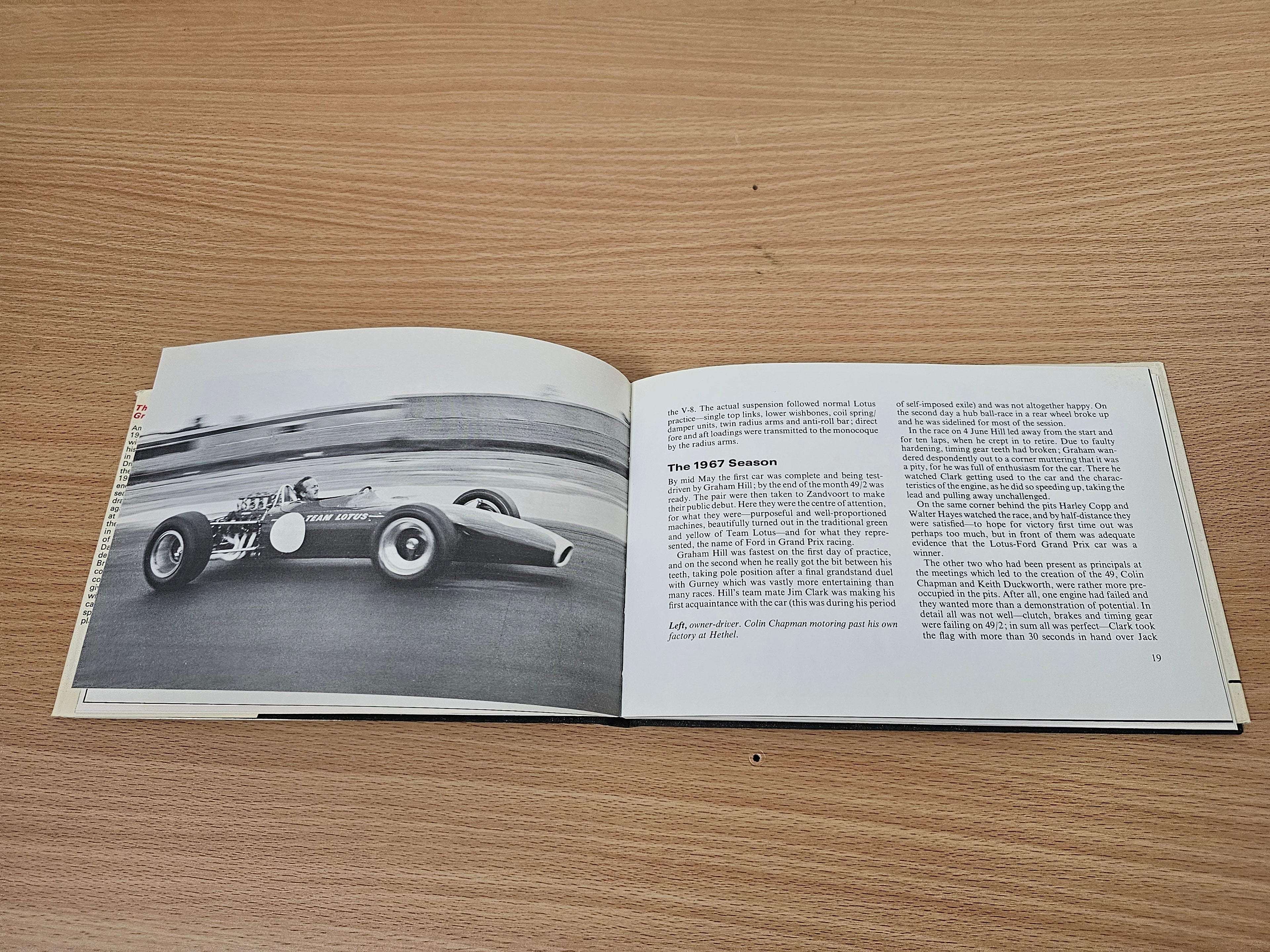 Open book with a black-and-white race car photo on the left and article text