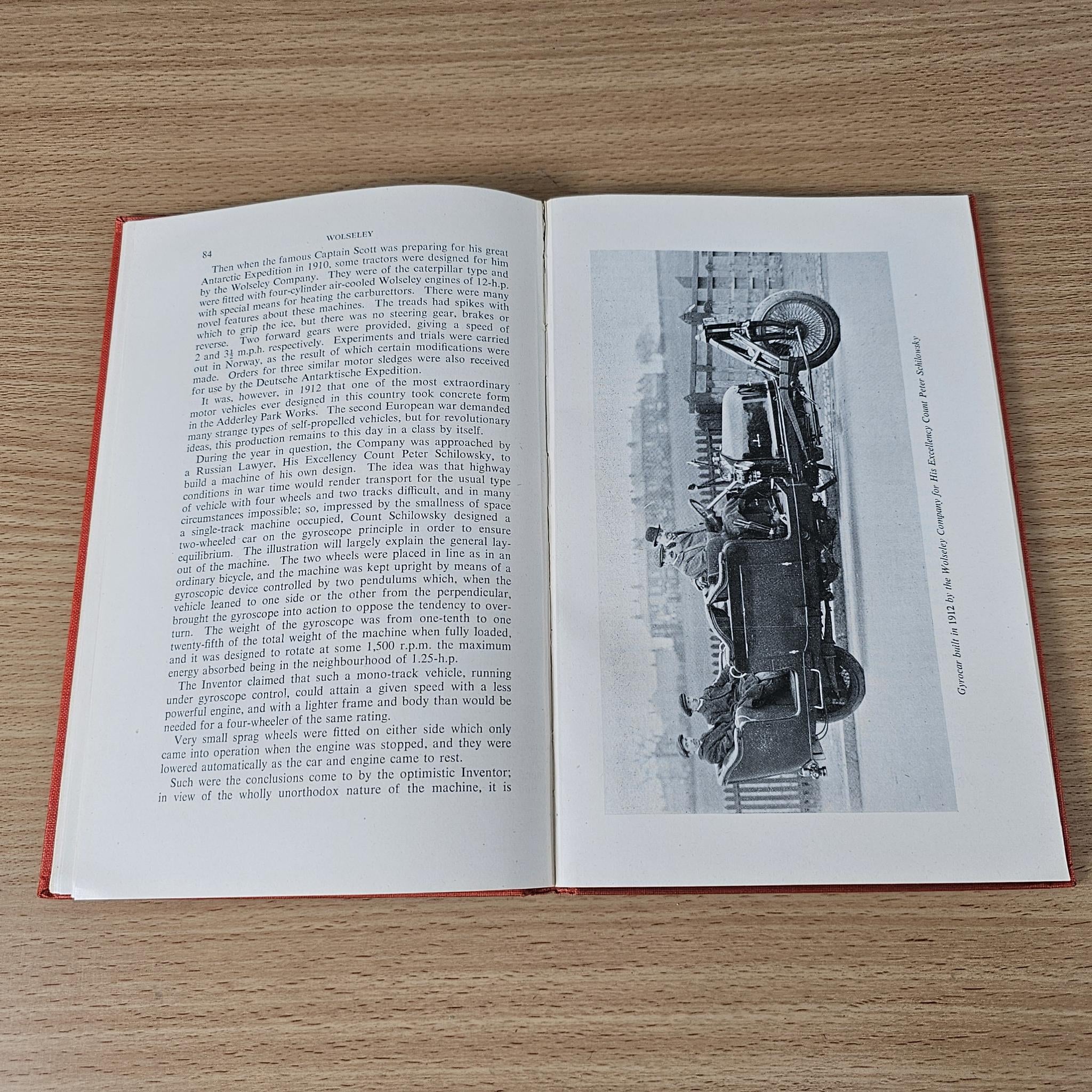 Open book with text on the left page and a large black-and-white machine photo on the right