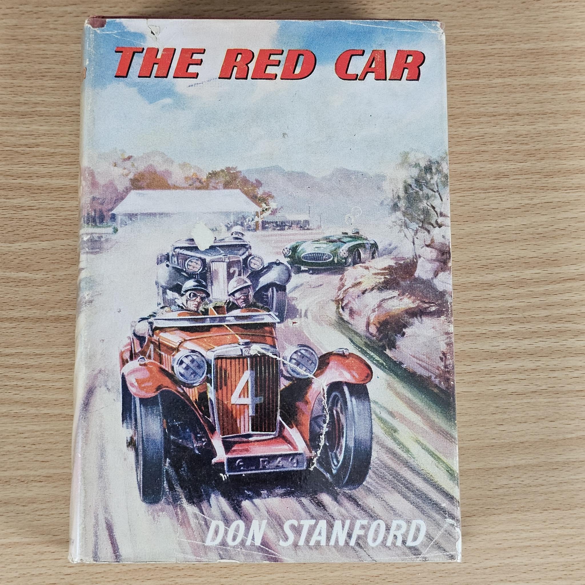 Paperback book with illustrated cover showing race cars and the title in red lettering.