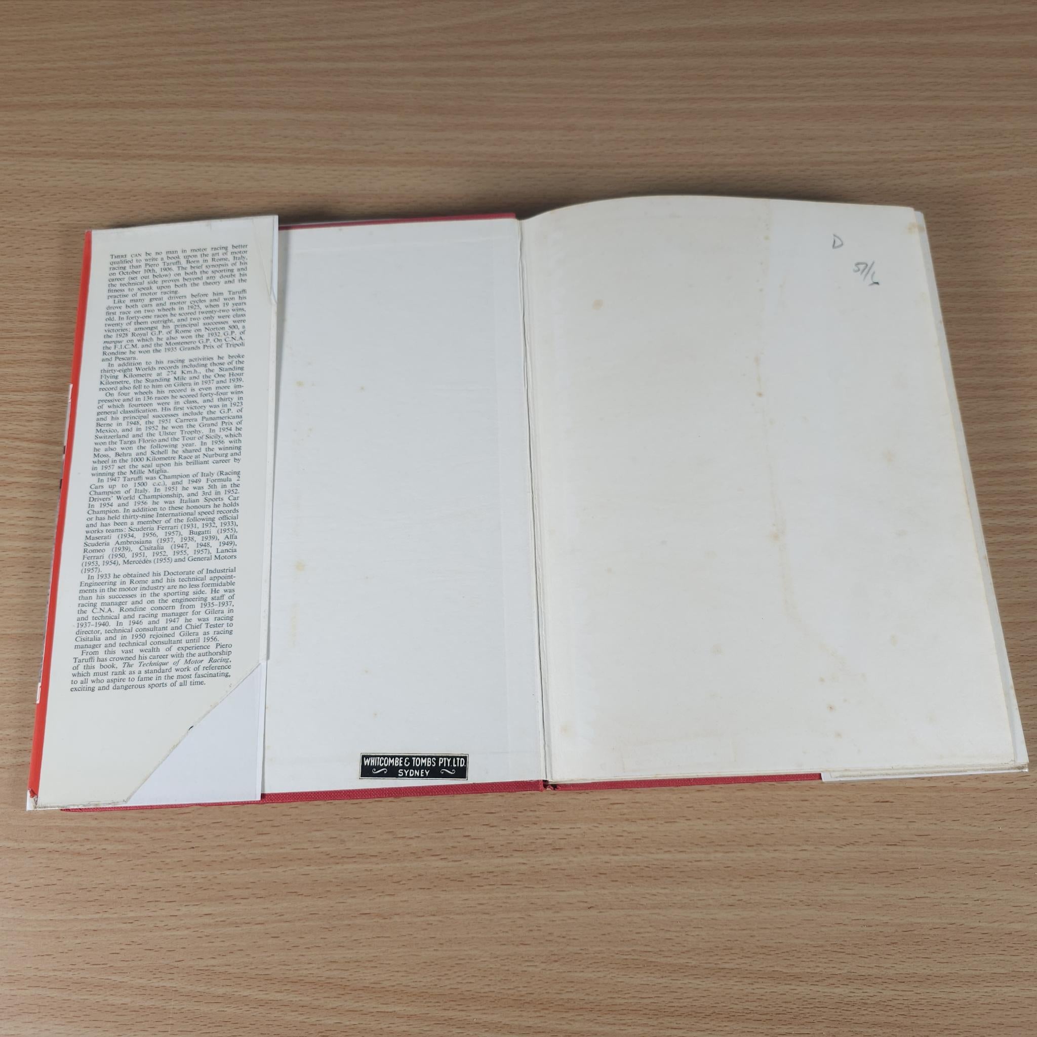 Open motor racing book with blank white pages and red-edged binding