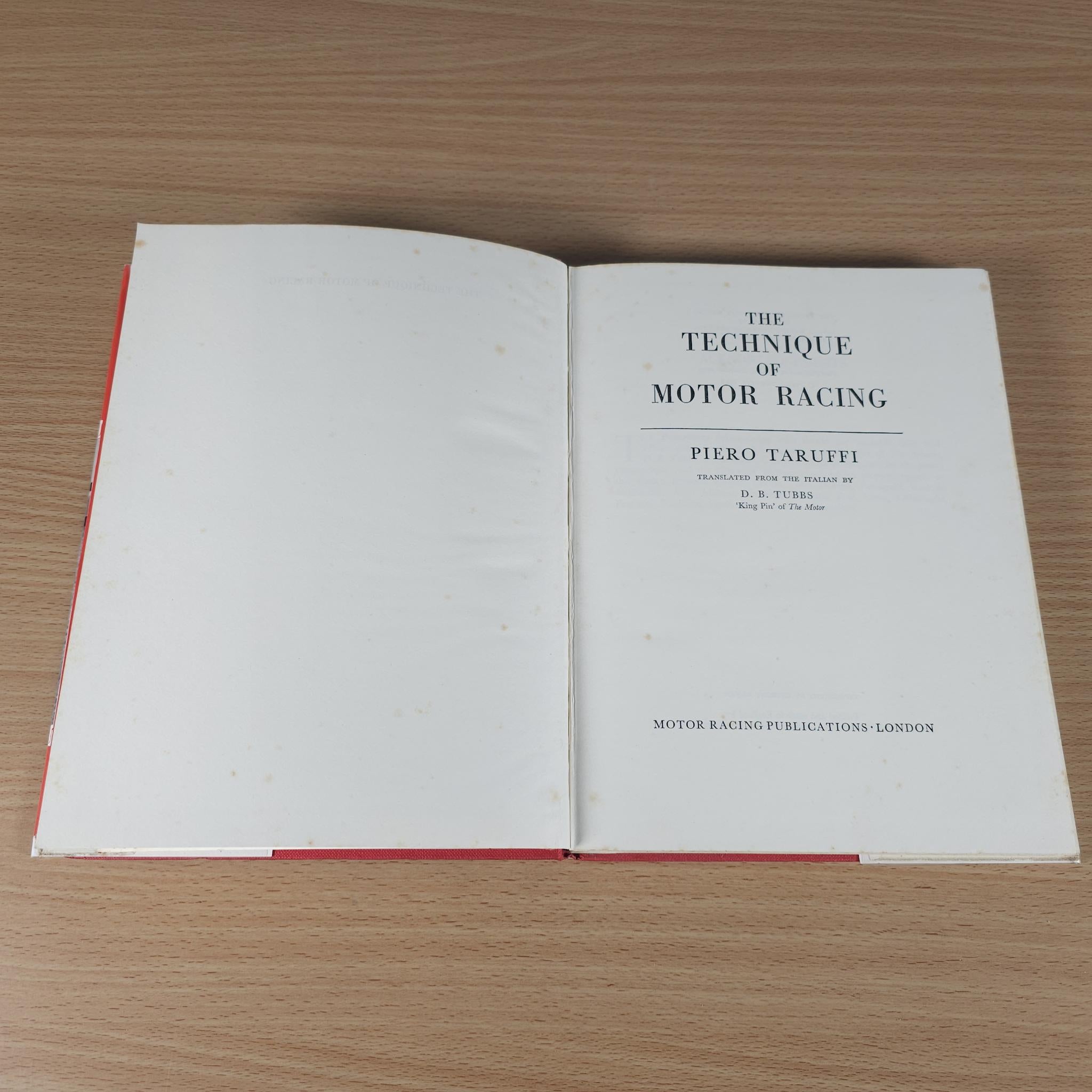 Open motor racing book showing title page text and red-edged binding