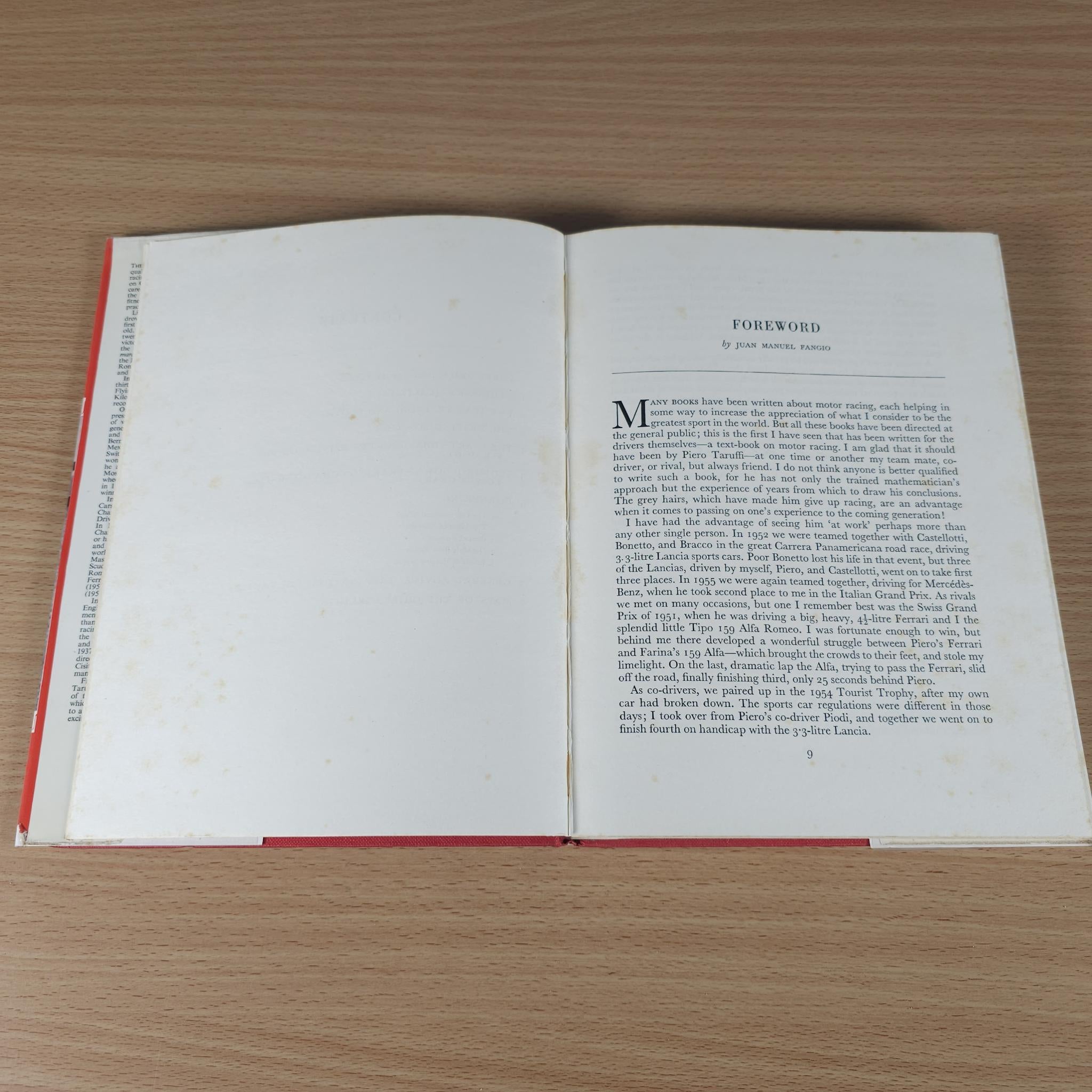Open motor racing book showing foreword page with dense text and red-edged binding