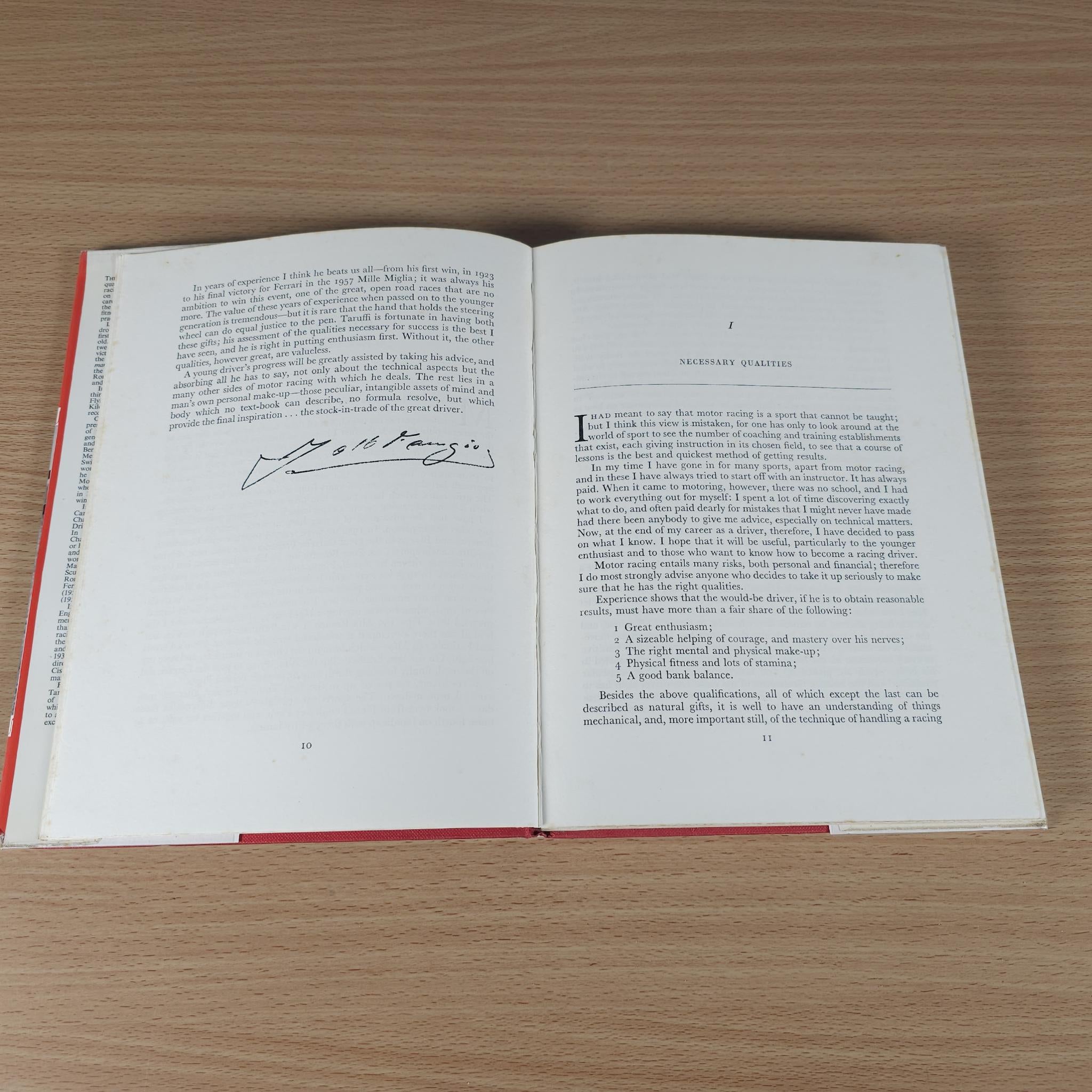 Open motor racing book page spread with handwritten signature and body text