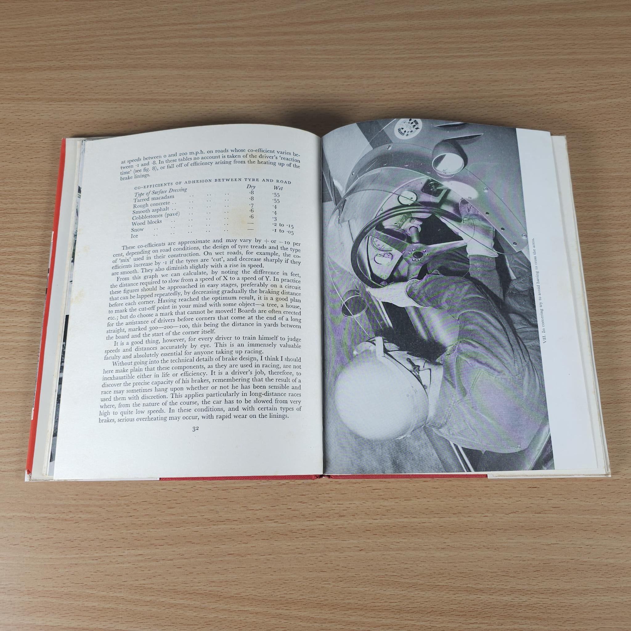 Open motor racing book with black-and-white photo of driver and vehicle cockpit