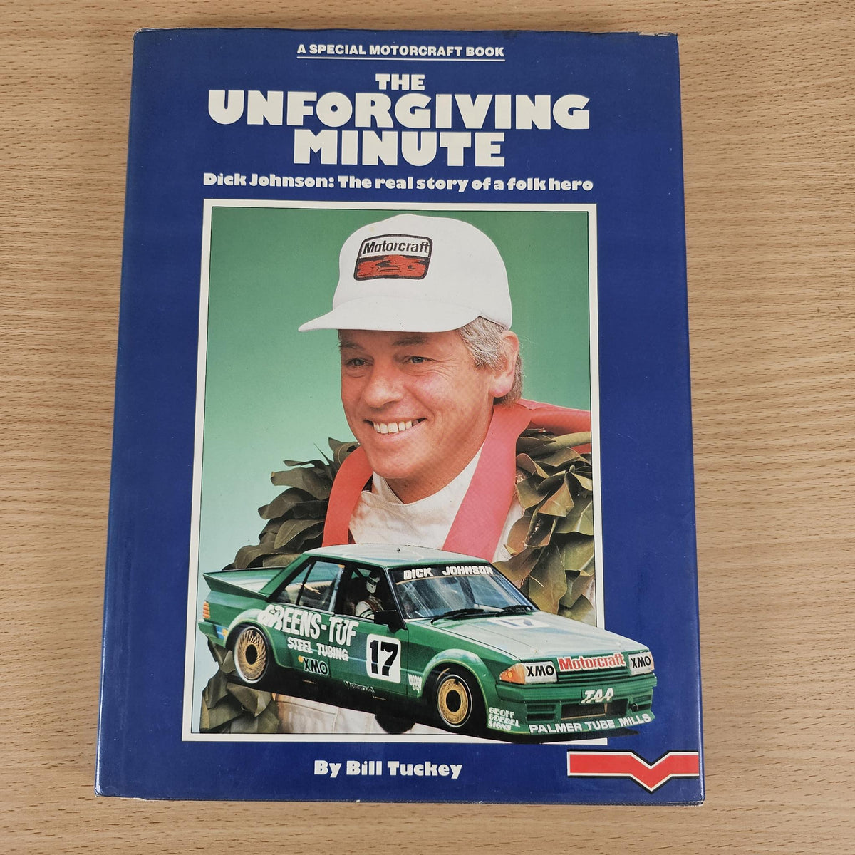 Hardcover racing biography book with blue cover, featured car and smiling man