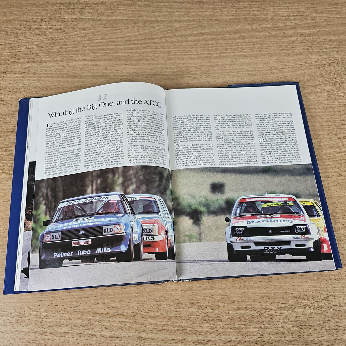 Hardcover book with open pages, text, and color photos of classic race cars
