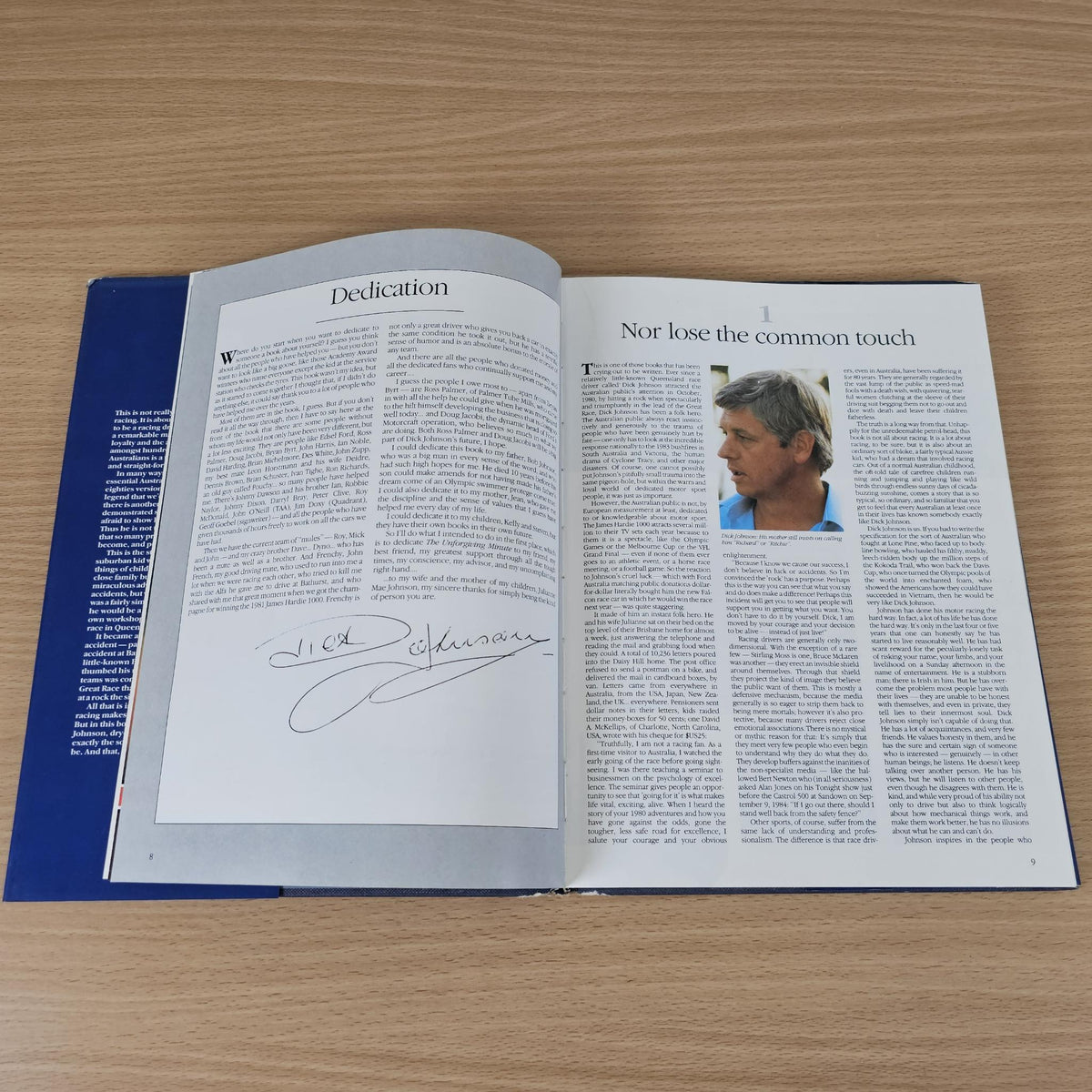 Opened hardcover book with “Dedication” page and two-column article text