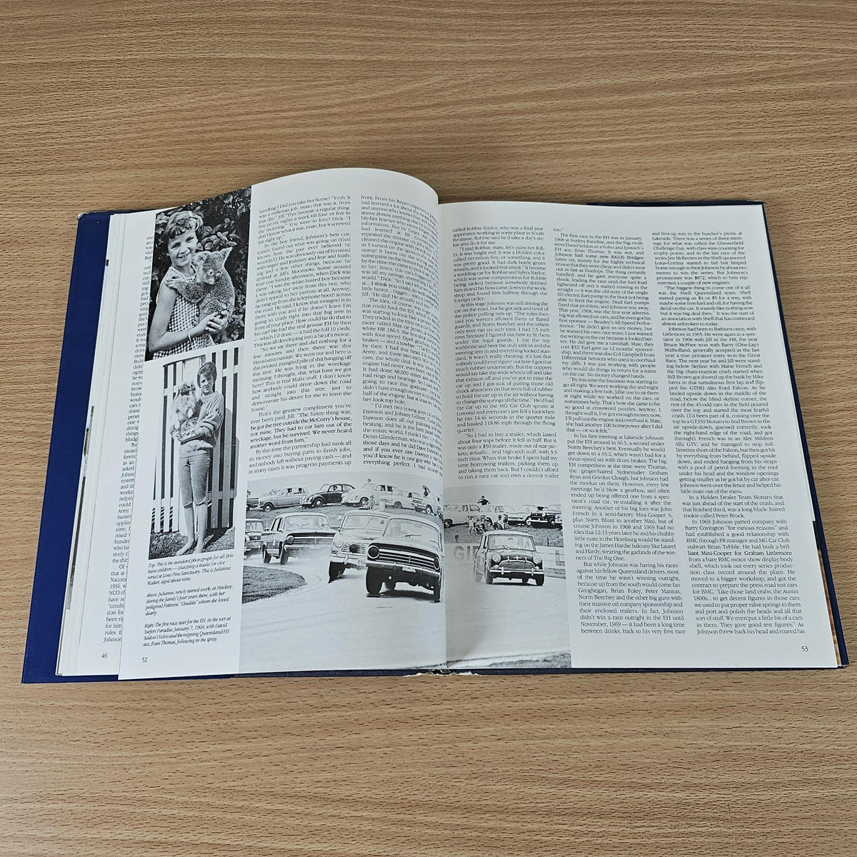 Opened hardcover book with black-and-white car photos and dense two-page text
