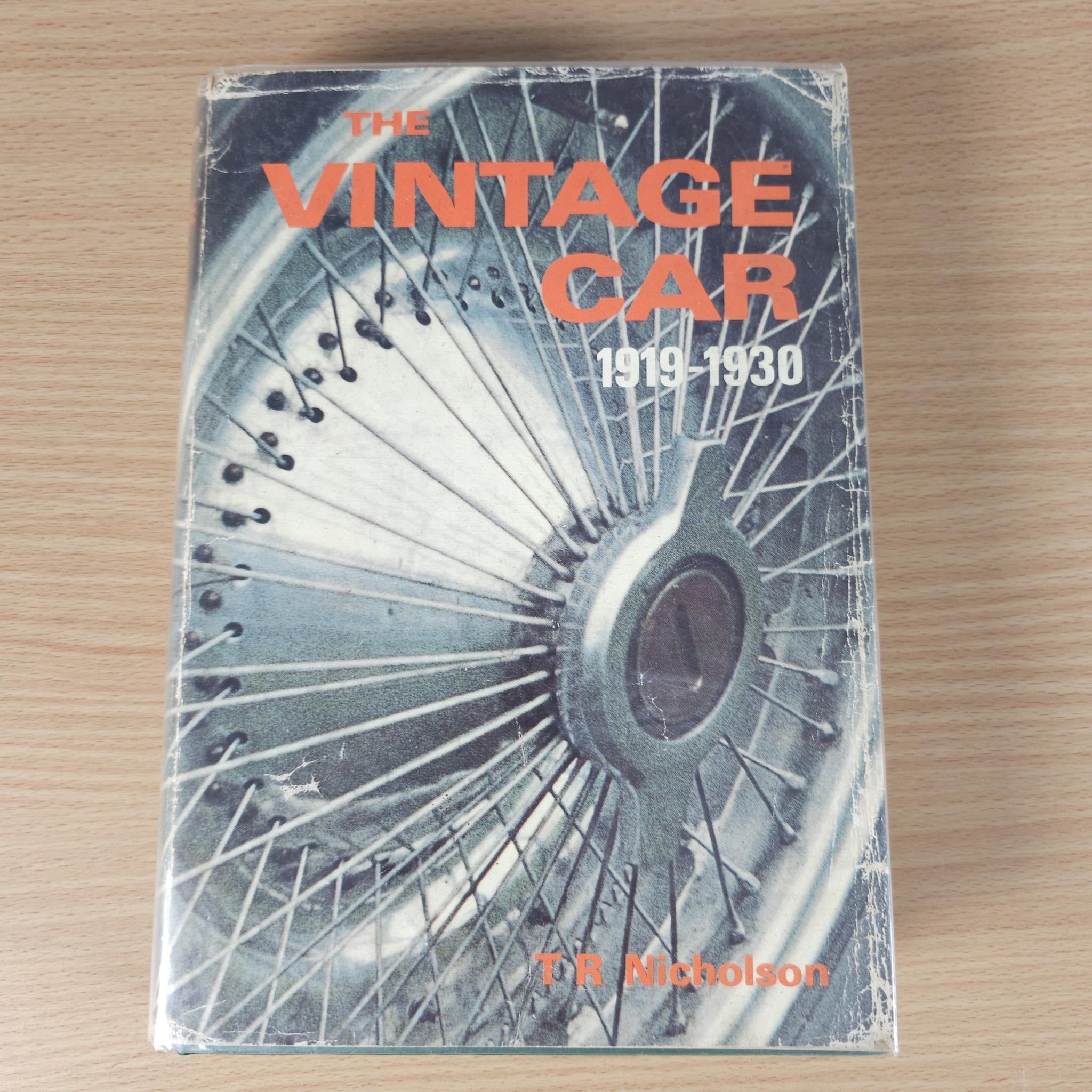 Vintage car history book with illustrated cover showing a spoked wheel and orange title.