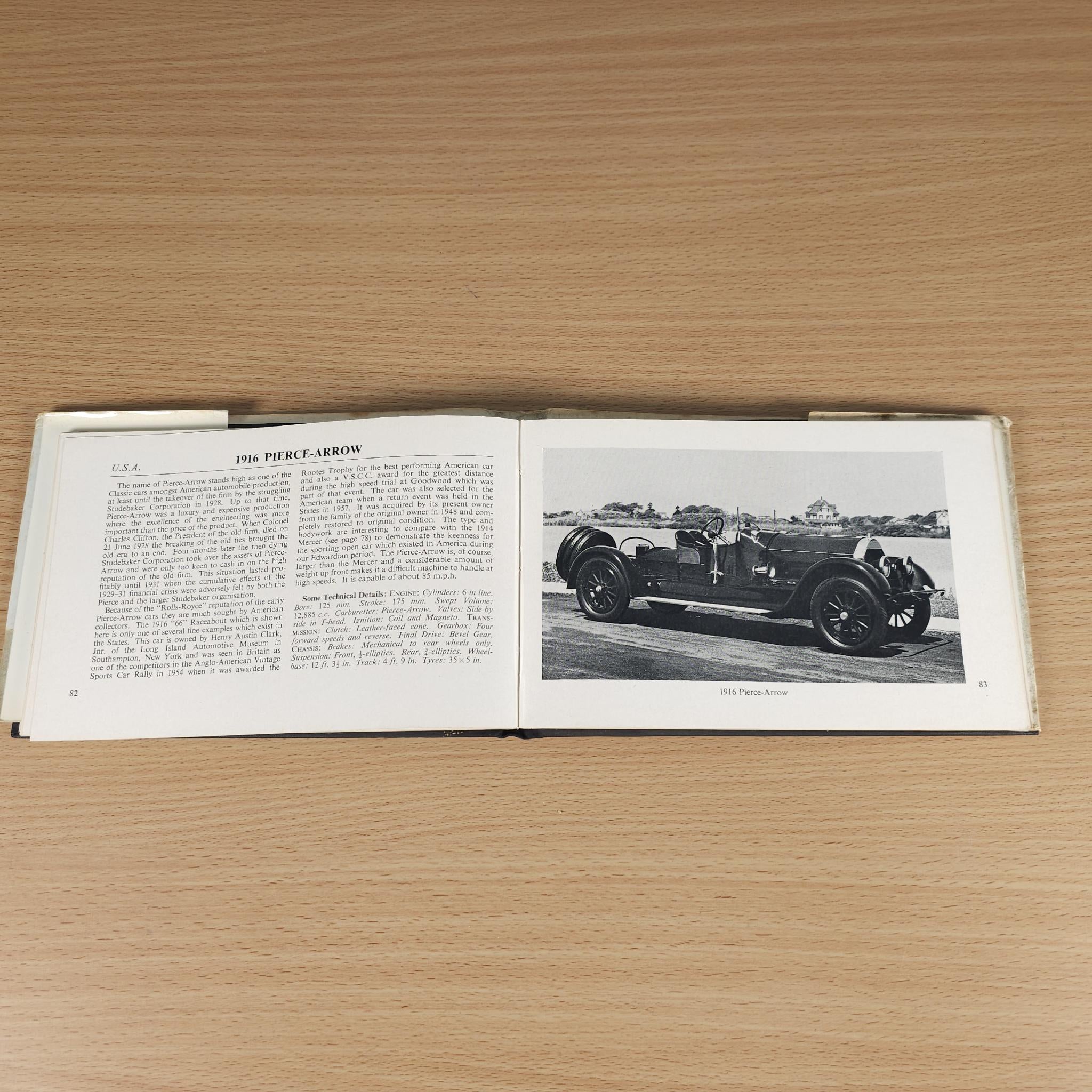 Vintage car guide book, open pages with text and black-and-white car photo