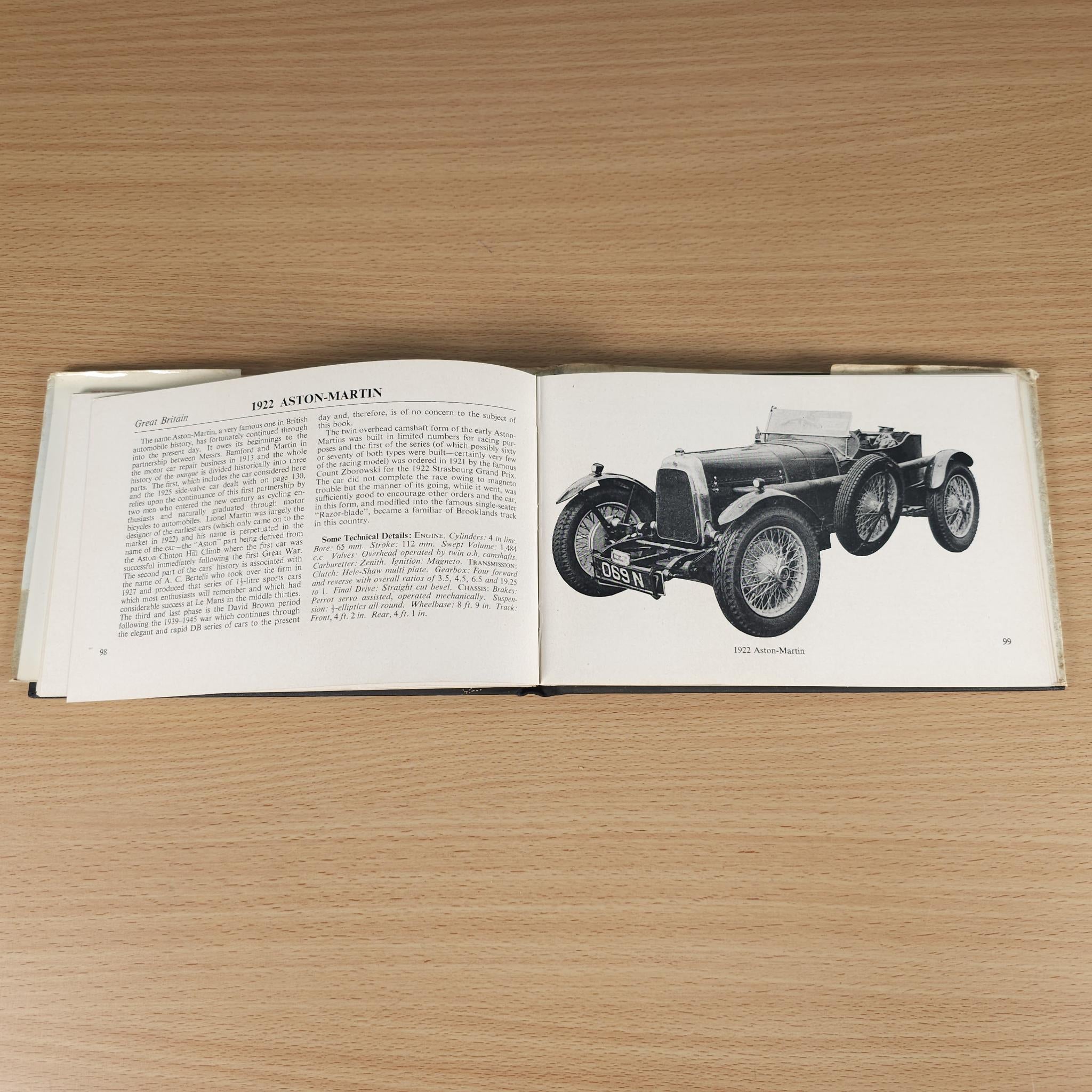 Vintage car guide book, open pages with text and Aston-Martin black-and-white car photo