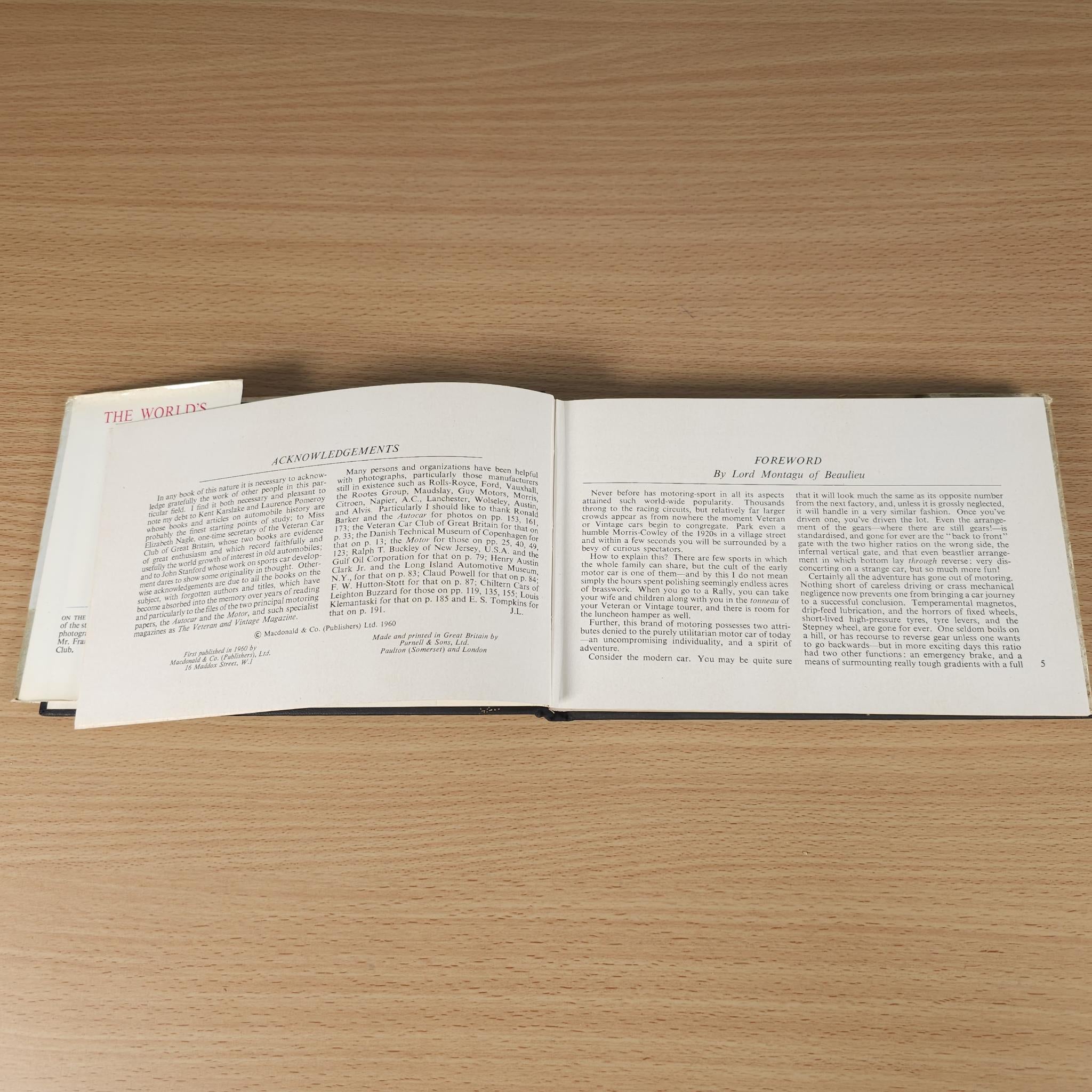 Opened vintage car book showing dense text on both pages