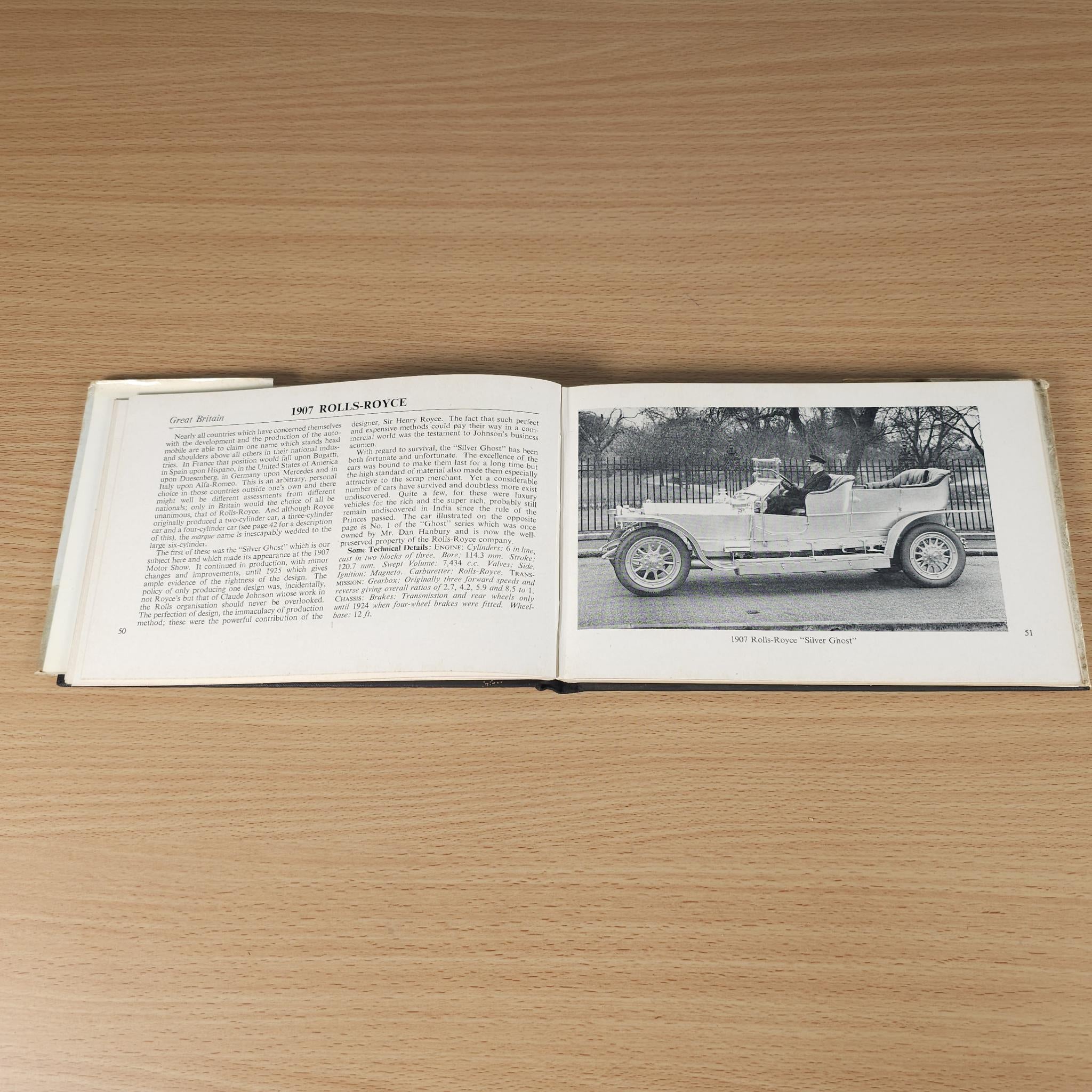 Opened vintage car book with illustrated car photo inset on the right