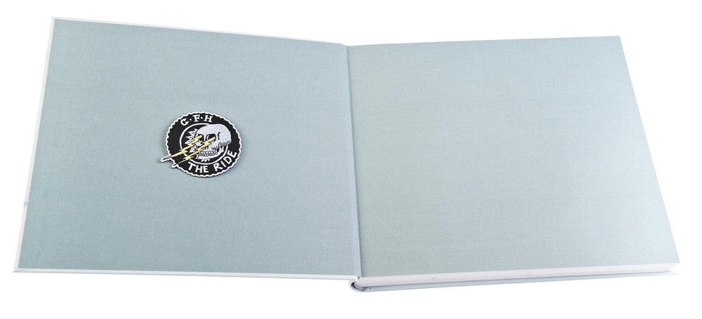 Motorcycle book closed with a round "THE RIDE" emblem on the front cover