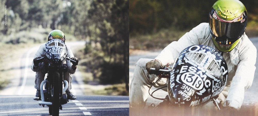 Two motorcyclists on a road wearing helmets and a white "Porsche" style hoodie