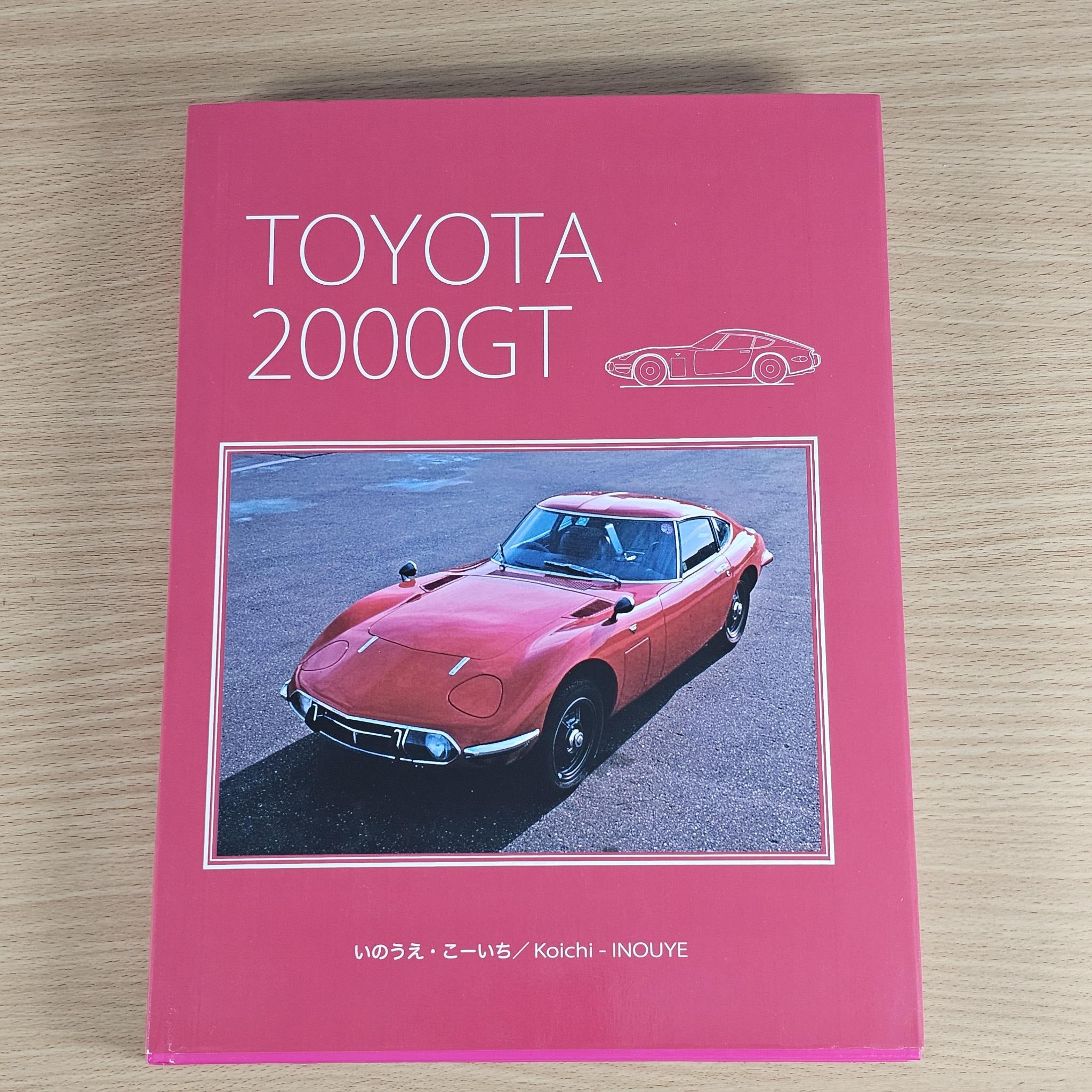 Pink hardcover car book cover with sports car photo and Toyota 2000GT title