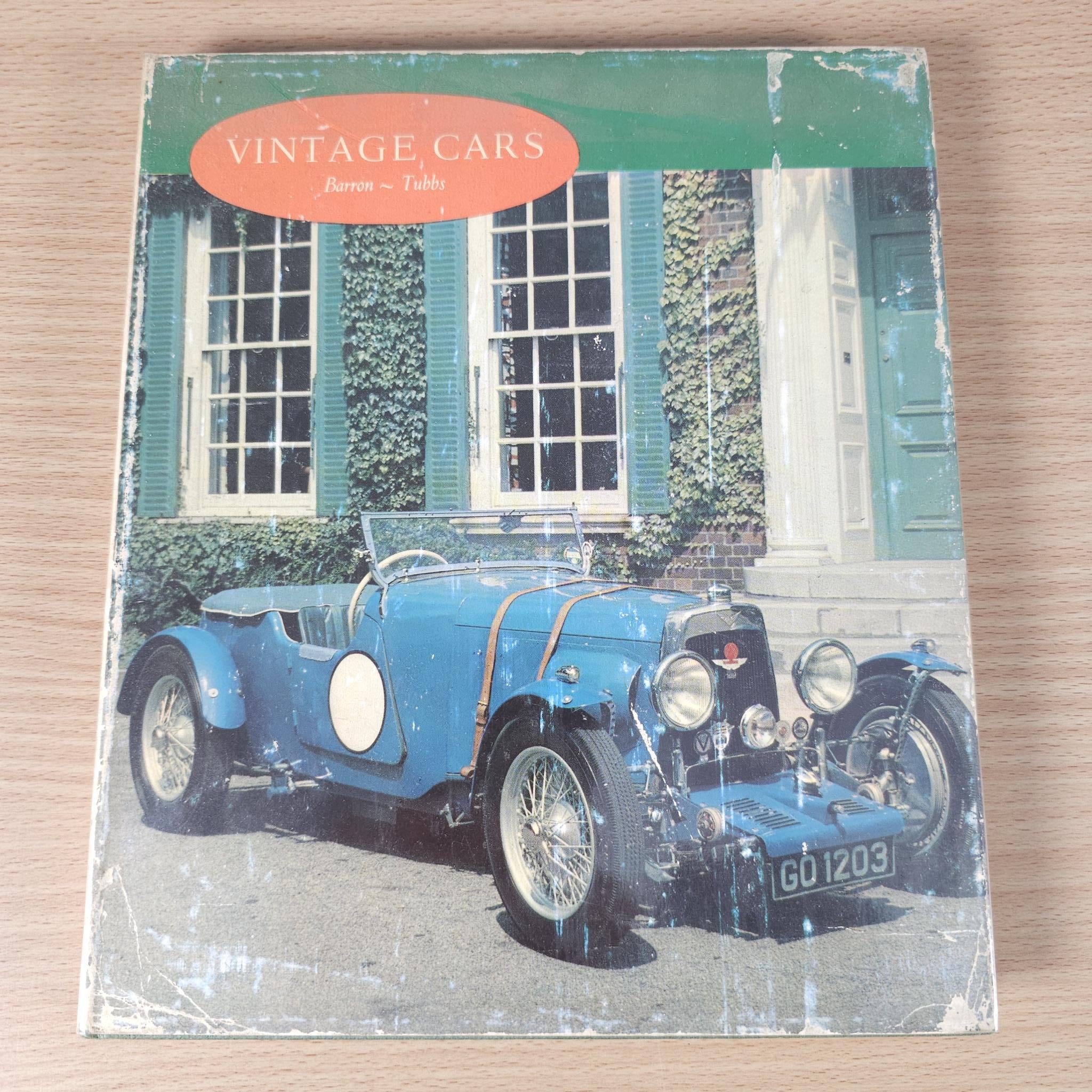 Vintage cars book front cover featuring a blue vintage car and orange title banner