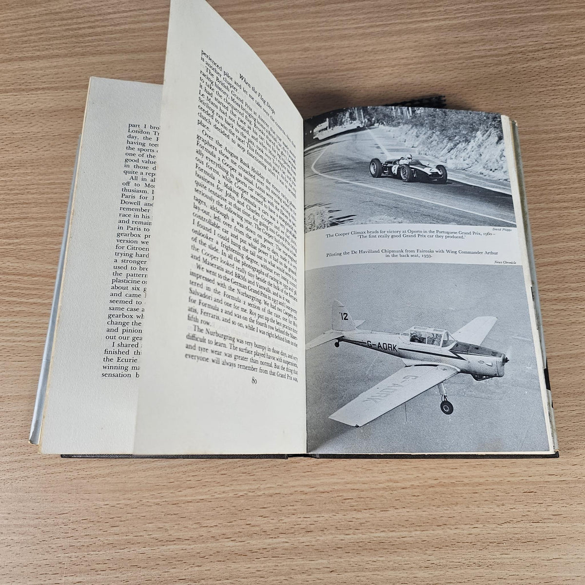 Open hardcover book with printed text and black-and-white race car and aircraft photos
