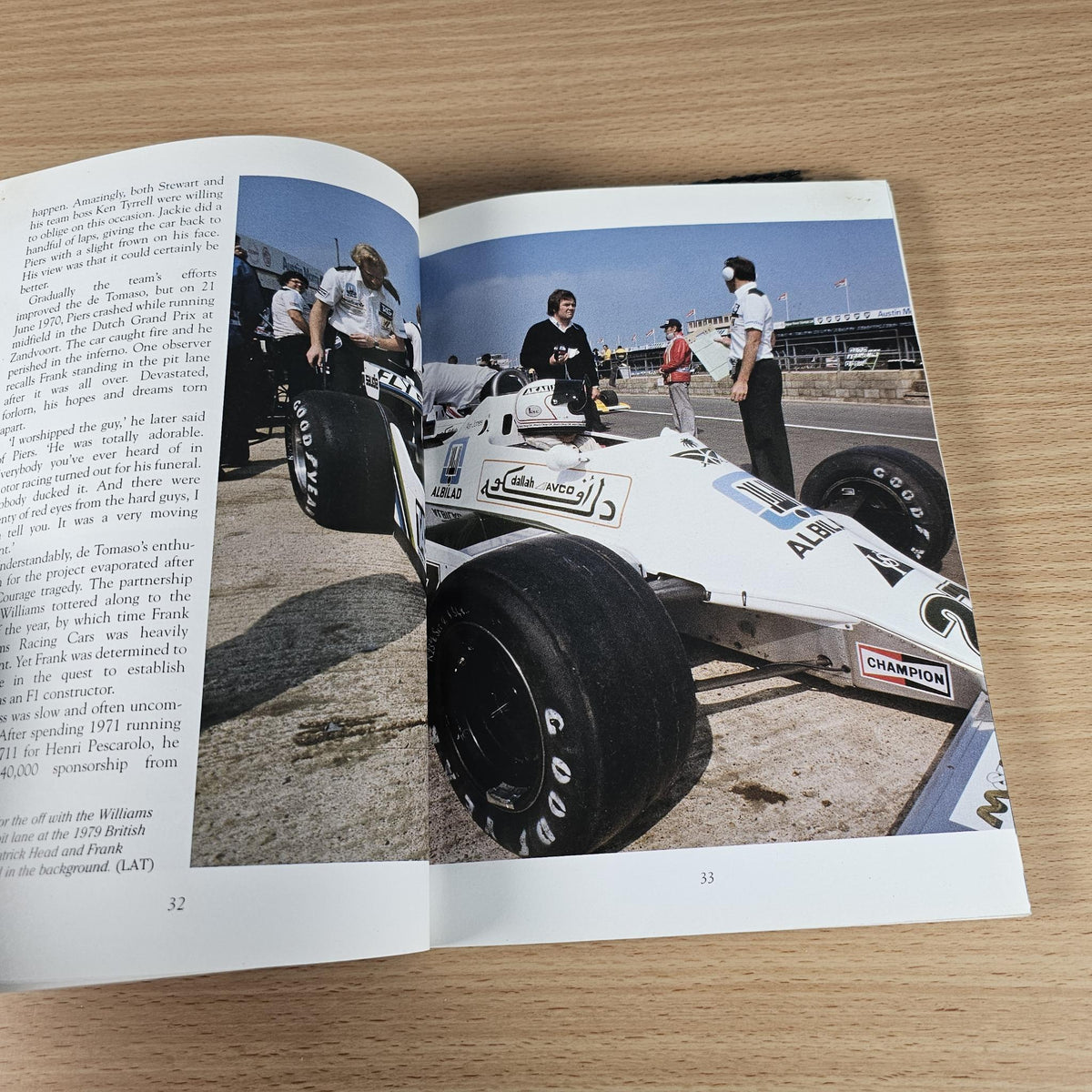 Open book spread featuring a white race car photo and surrounding black text columns